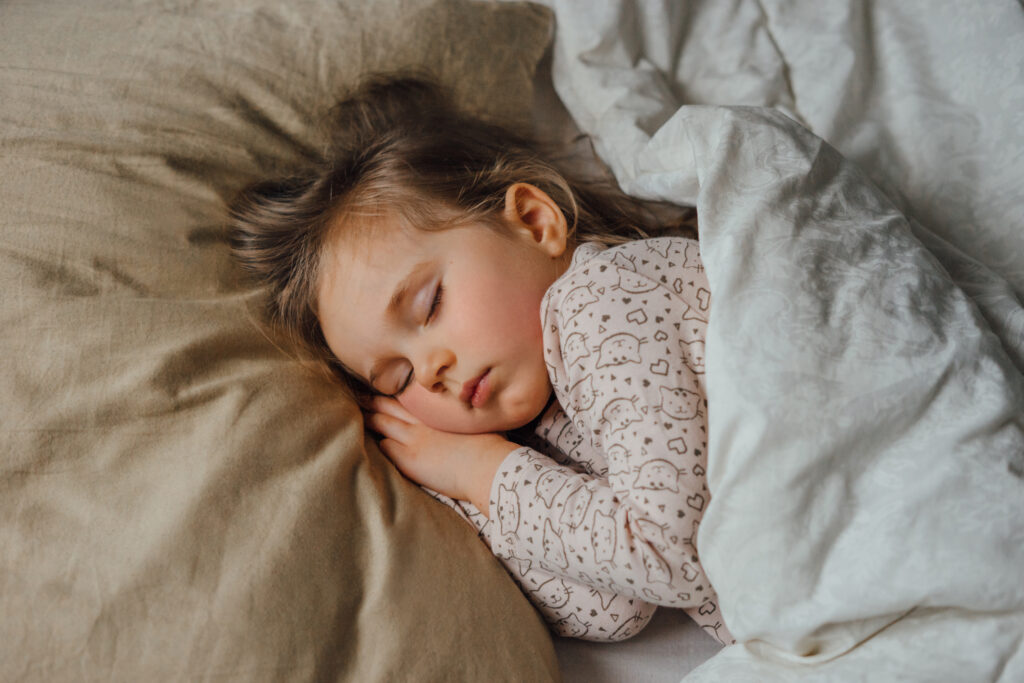 Little girl sleeping in bed at home, top view