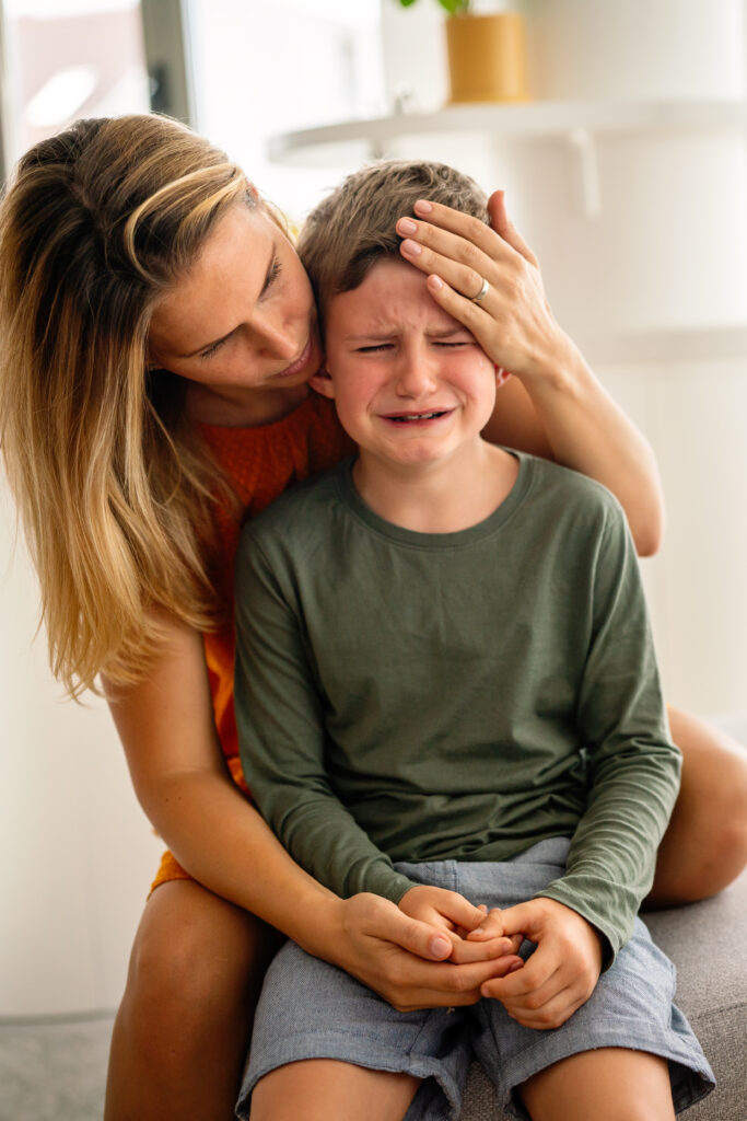 Portrait of mother consoling her crying sad injured son. Child family support pain parent concept